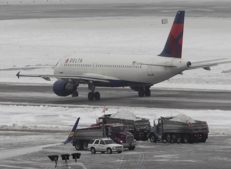 A plane taxiing on a snowy runway.