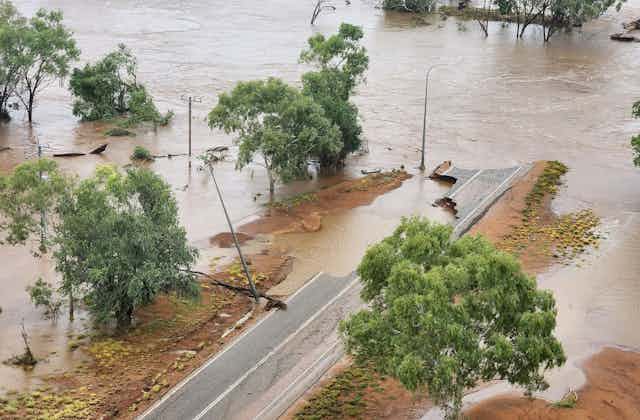 A road which is partially destroyed by flooding.