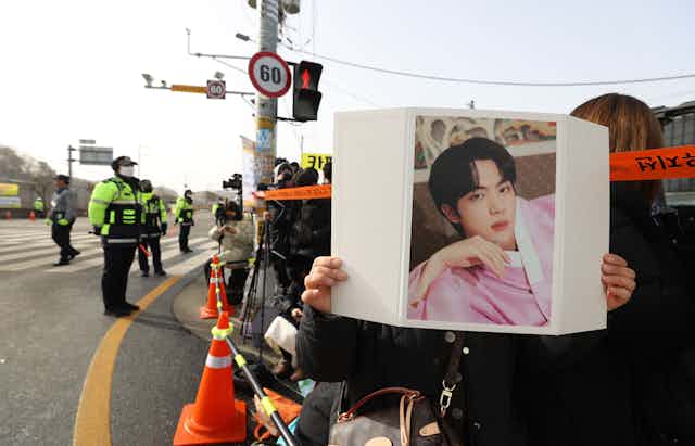 BTS fans outside a Korean army barracks guarded by police.