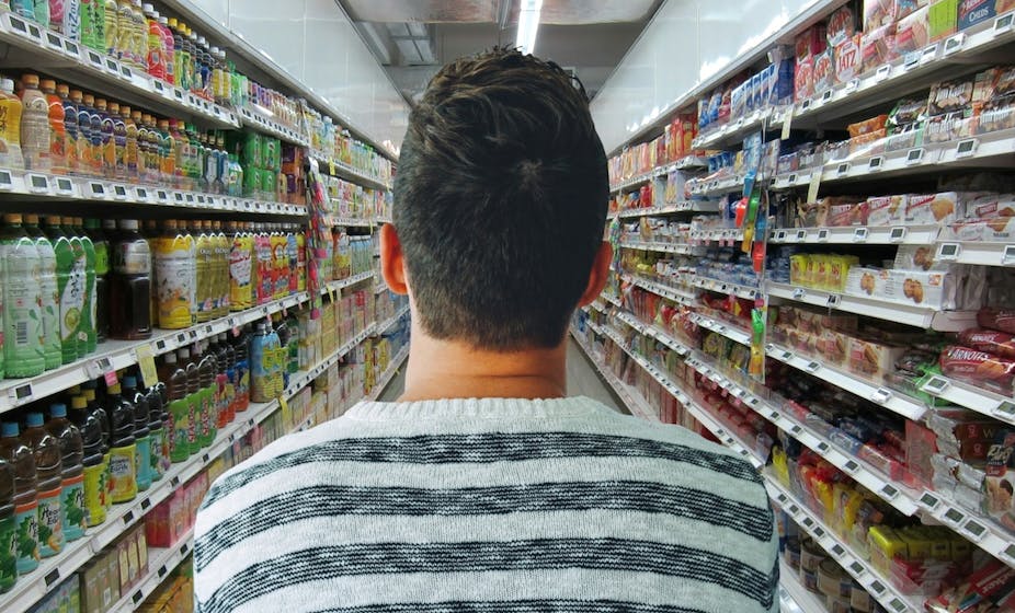 Homme hésitant dans un rayon de supermarché