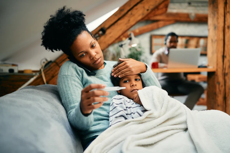 A mother takes a sick child's temperature.