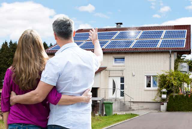 Couple looking at new solar panels on roof of their home