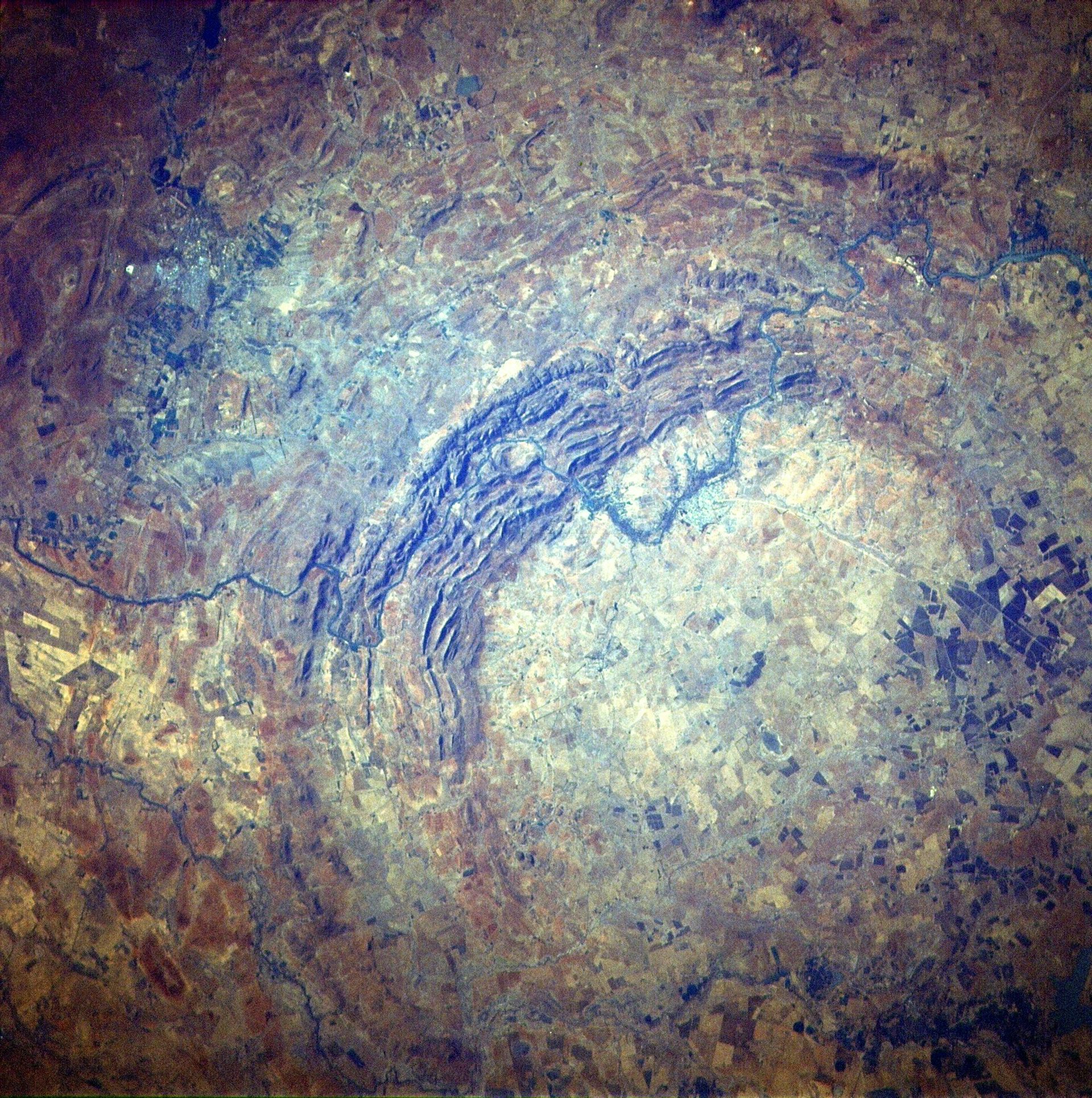 A large rocky circle on a red landscape seen from above.