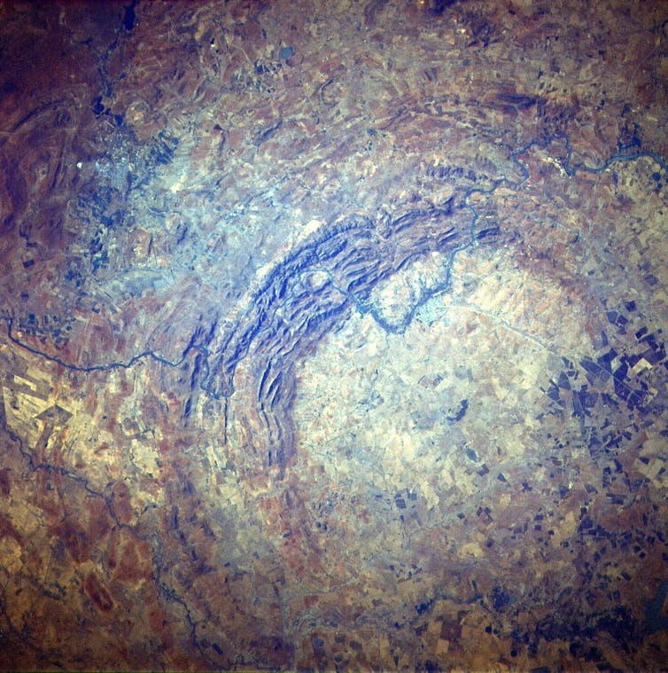 A highly detailed overhead view of a rocky orange-yellow landscape with a circular structure in it