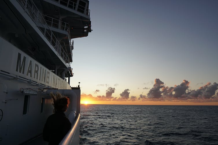 Person watching the sunset from a ship