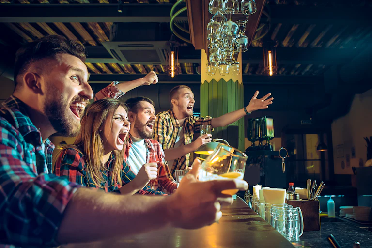 Friends drink alcohol in a bar, look intoxicated.