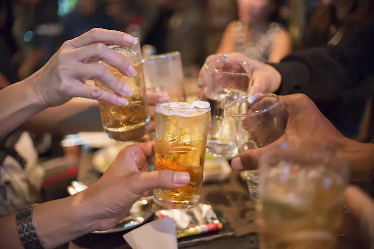 Hands hold glasses and cheers.