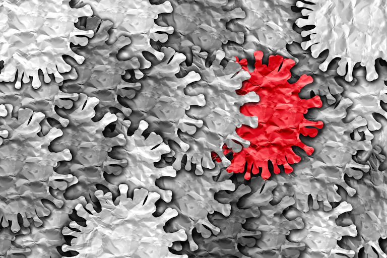 Illustration of a red coronavirus in a large group of gray coronaviruses