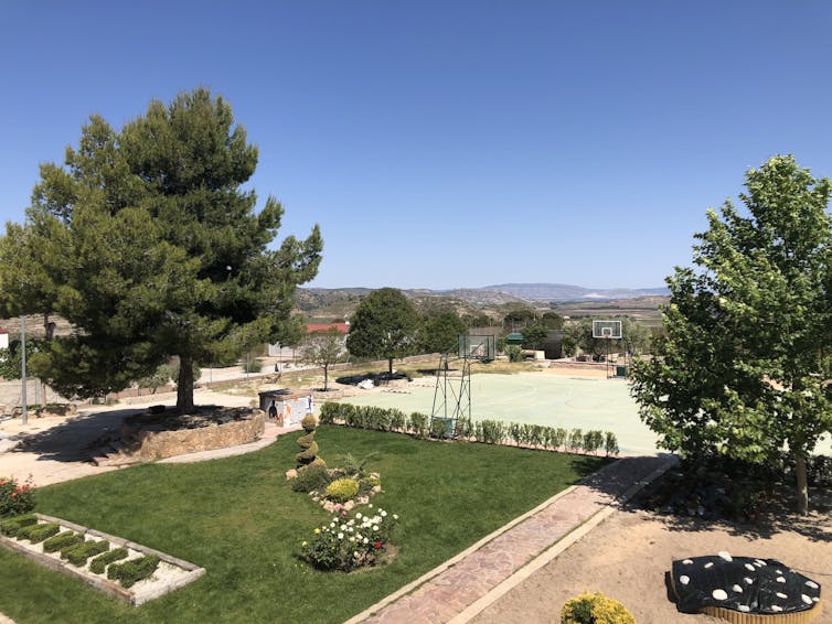 An outdoors area with trees and a garden.