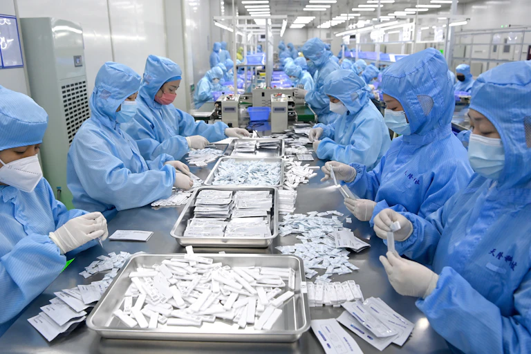 workers in protective wear prepare COVID tests in lab