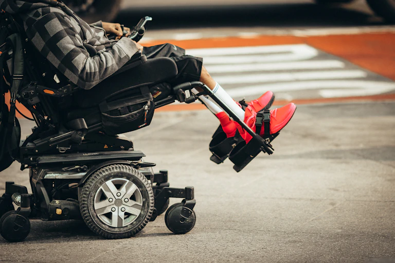 person in wheelchair at street crossing