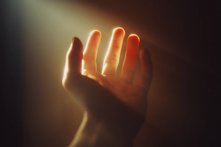 A human hand with bright illumination on a sepia background