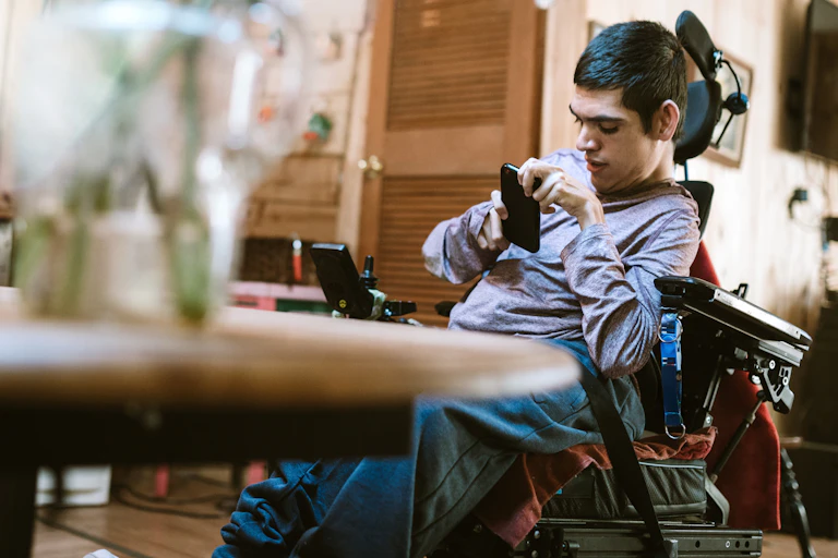 Man in wheelchair uses mobile phone