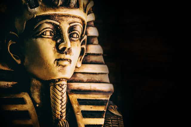 Golden pharaoh mask on dark background