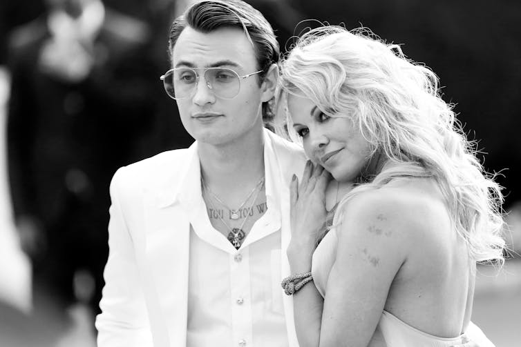 A black and white photo shows Pamela leaning affectionately on the shoulder of her adult son Brandon.