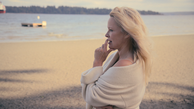 Pamela Anderson photographed this year, stood on a beach looking out to sea.