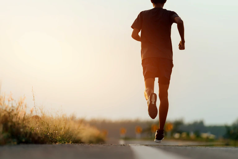 Un homme court sur route, vu de dos
