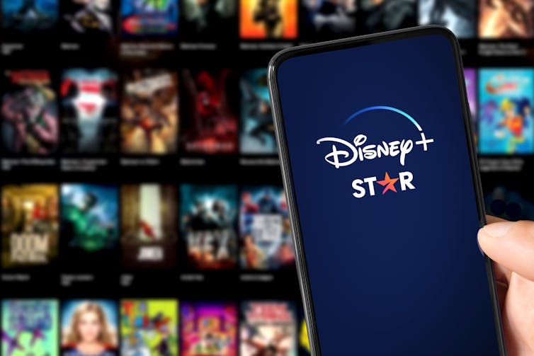 A phone screen displays both the Disney+ and Starlogos.