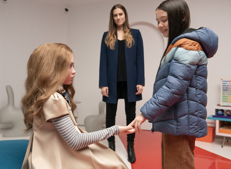 Cady (Violet McGraw) meets M3gan as her aunt Gemma (Allison Williams) watches on.
