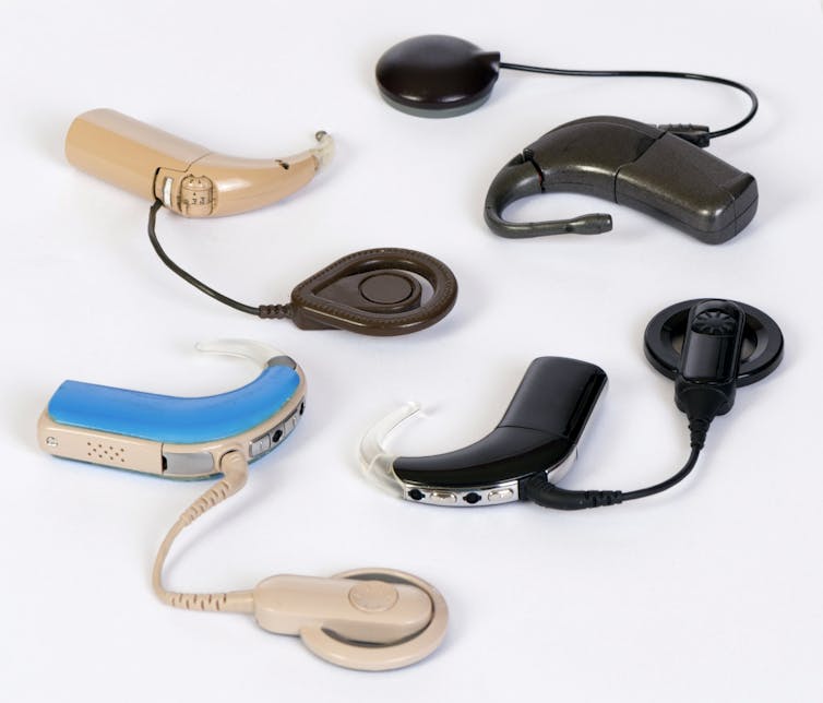 Four cochlear implants of different colors.