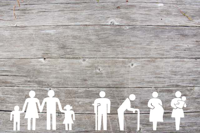 a row of illustrated silhouetted white figures representing a family, the elderly, a person using a crutch, a pregnant woman and a woman carrying a young child.