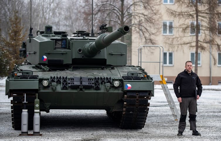 A man stands next to a German Leopard tank.