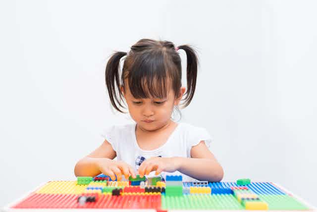 Little girl playing with building blocks