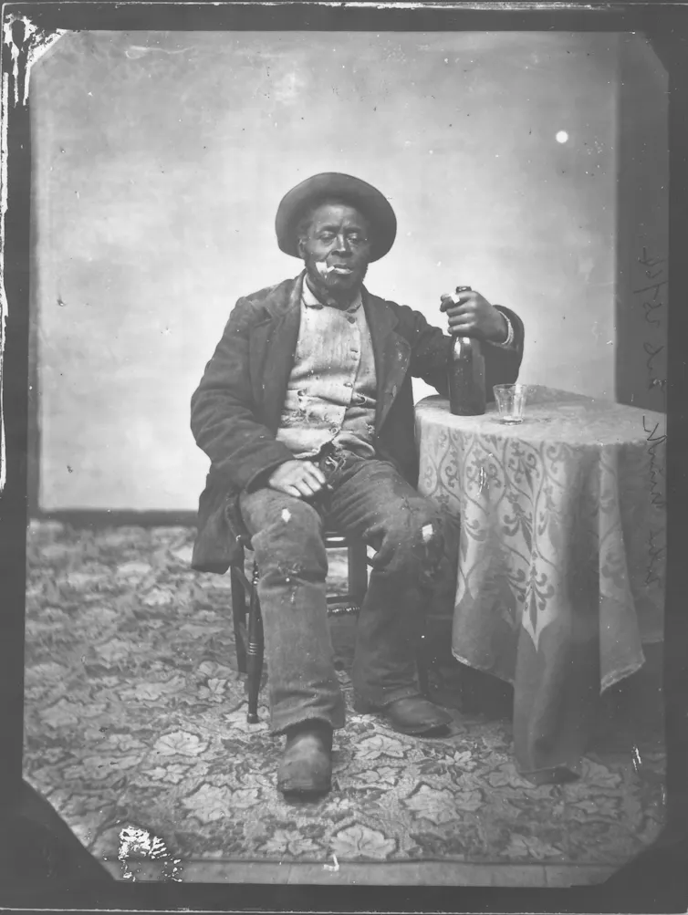 A man seen sitting in a chair in black and white photograph.