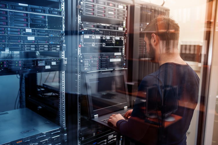 un homme analyse les données de serveurs informatiques