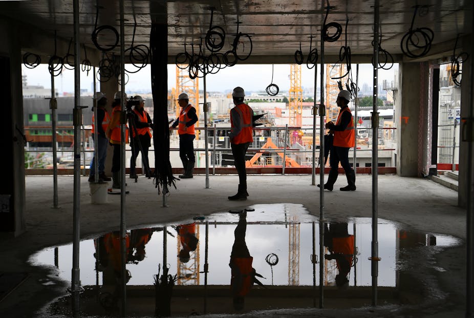 Des individus portant des gilets orange sur un chantier