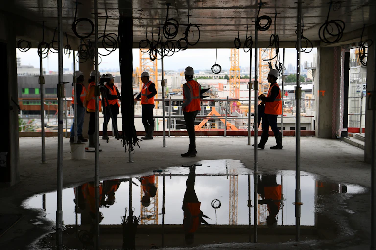 Des individus portant des gilets orange sur un chantier