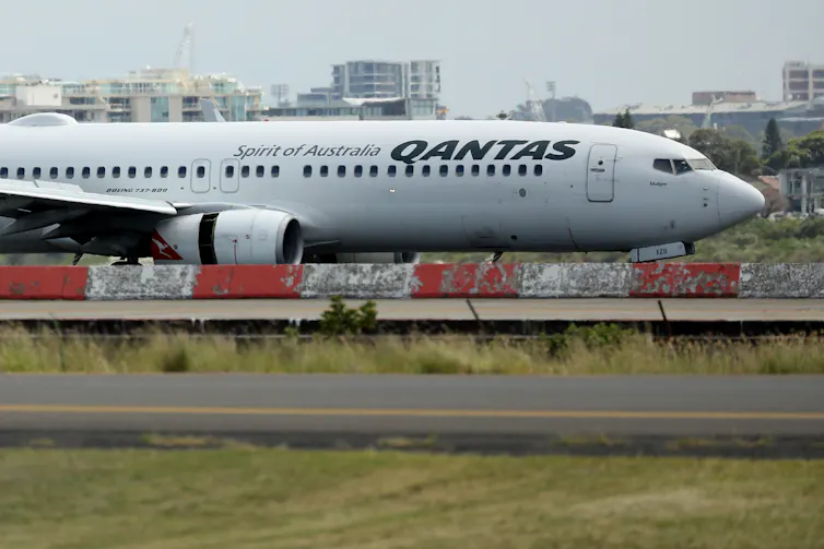 A Qantas plane sits on the tarmac.