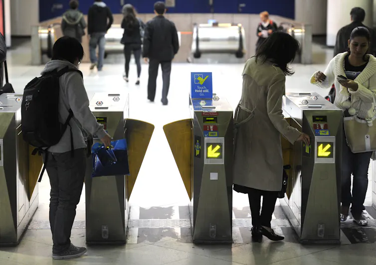 People present their myki cards to pass through the barriers at a public transport station