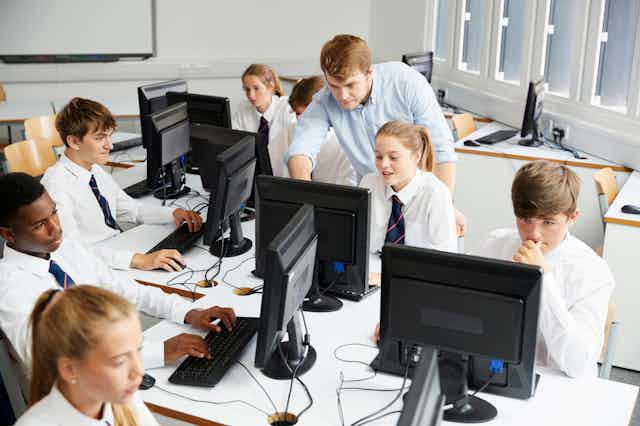 Class working on computers wearing uniform with ties