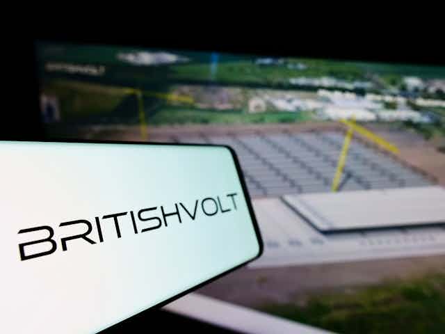 A smartphone displaying a Britishvolt logo in front of an artist's impression of the gigafactory.
