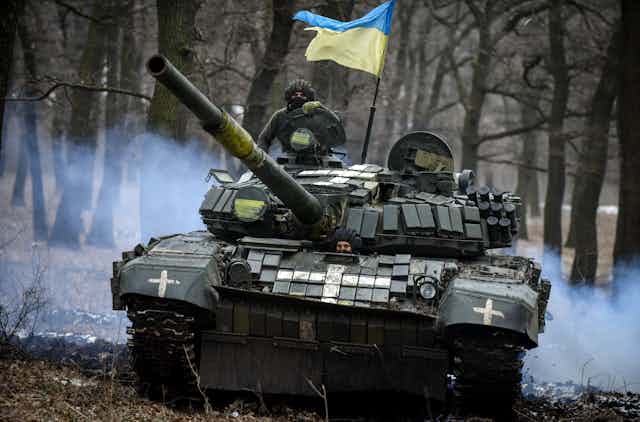  a Ukrainian Soviet-era T-72 tank drives through a forest.