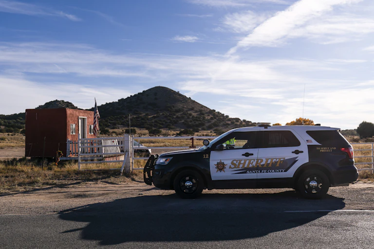 A sheriff's car parked next to a fence in New Mexico.