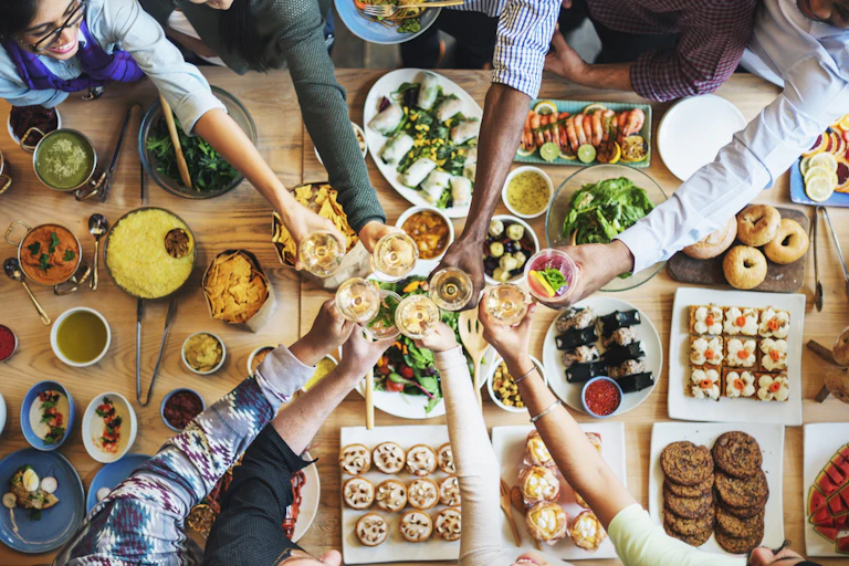 A team of people eat together, celebration, toast, happiness, wellbeing