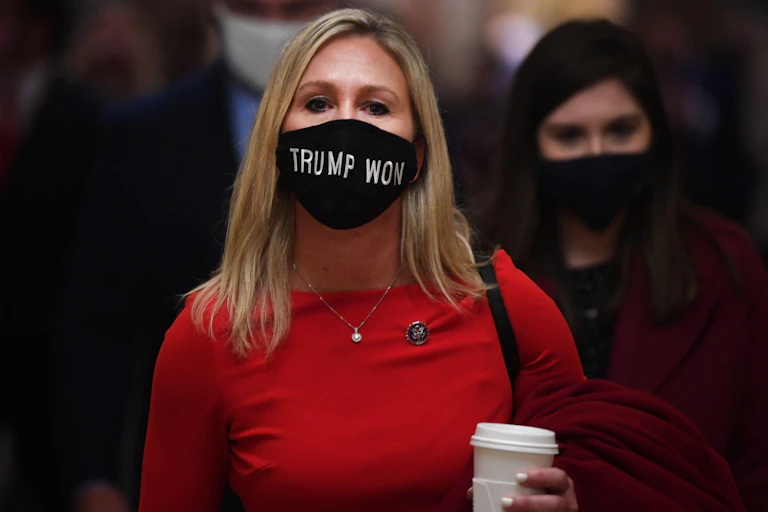A woman in a red dress wearing a mask saying "Trump won".