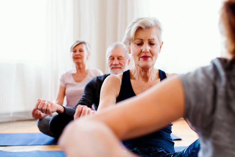 Des seniors des deux sexes sont en pleine séance de méditation