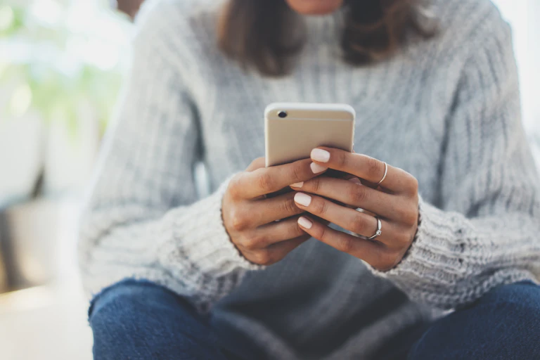Close up of a young woman's hands holding a smartphone