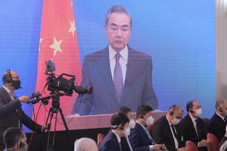 An image of a man on a screen and a video camera.