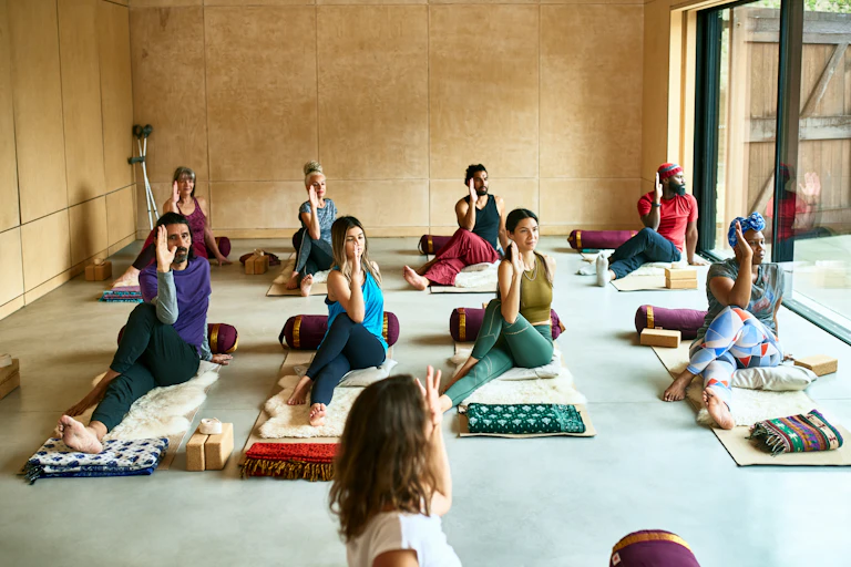 A group of people sitting on the floor doing yoga.