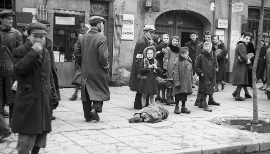 A small child lying on the sidewalk, presumably from starvation.
