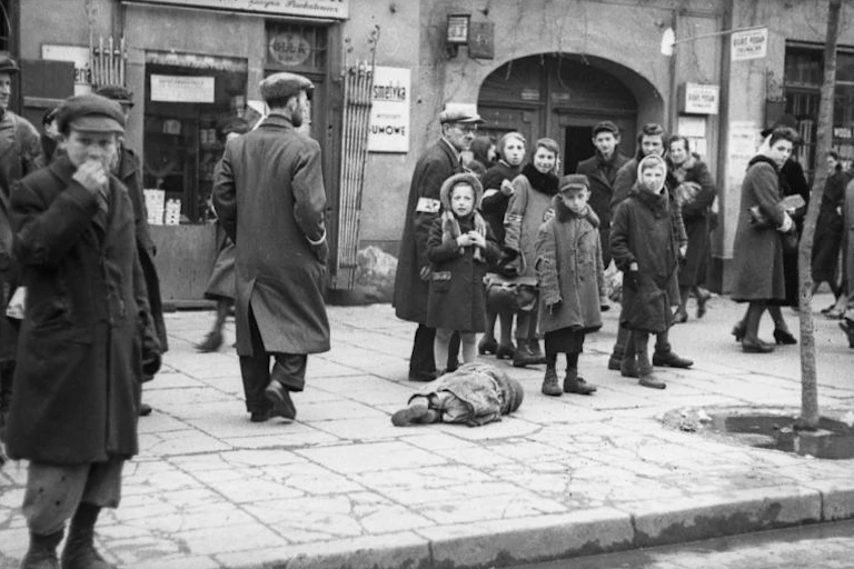 A small child lying on the sidewalk, presumably from starvation.