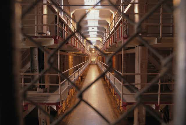 A view of a prison block, seen from behind fencing.