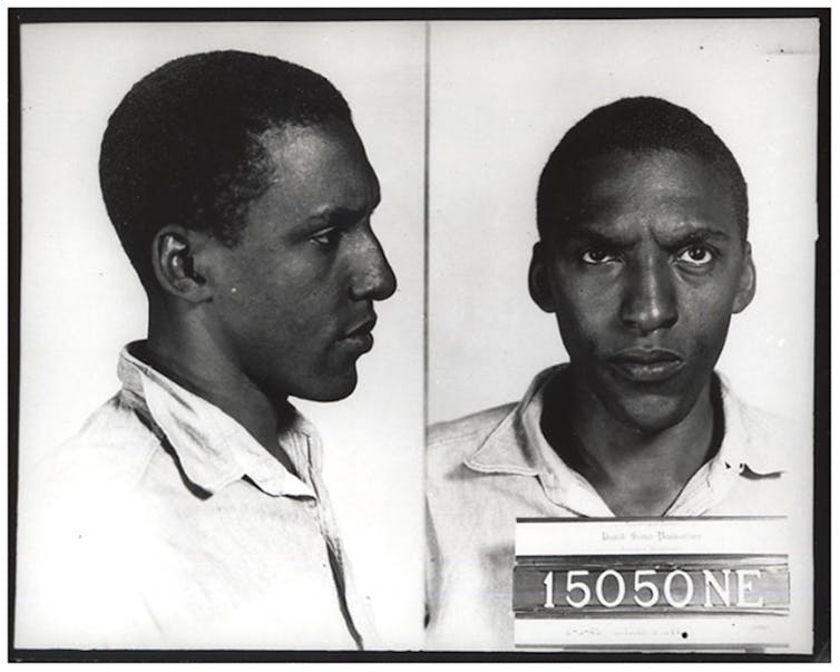 Two head shots of the same black man -- a side view and a head-on view -- are seen in these photographs taken in federal prison.