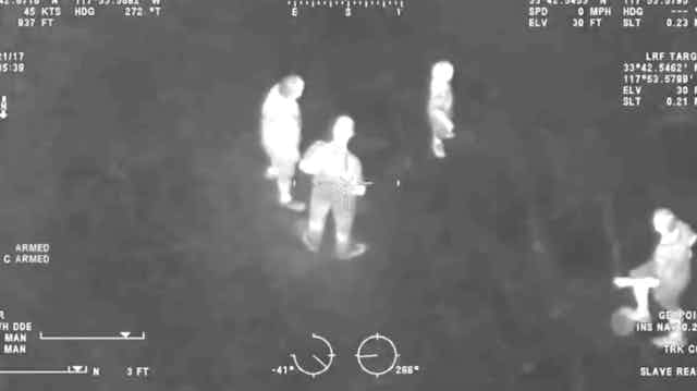 A nightvision image of a group of people seen from above. 
