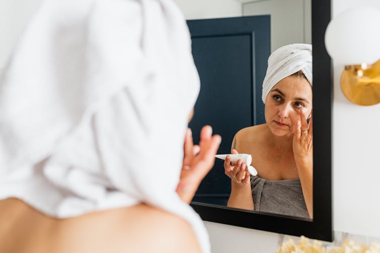 Woman applies sunscreen in the morning