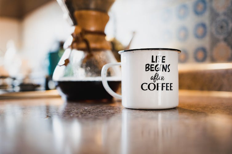 cups of coffee on table in mug that reads life begins with coffee